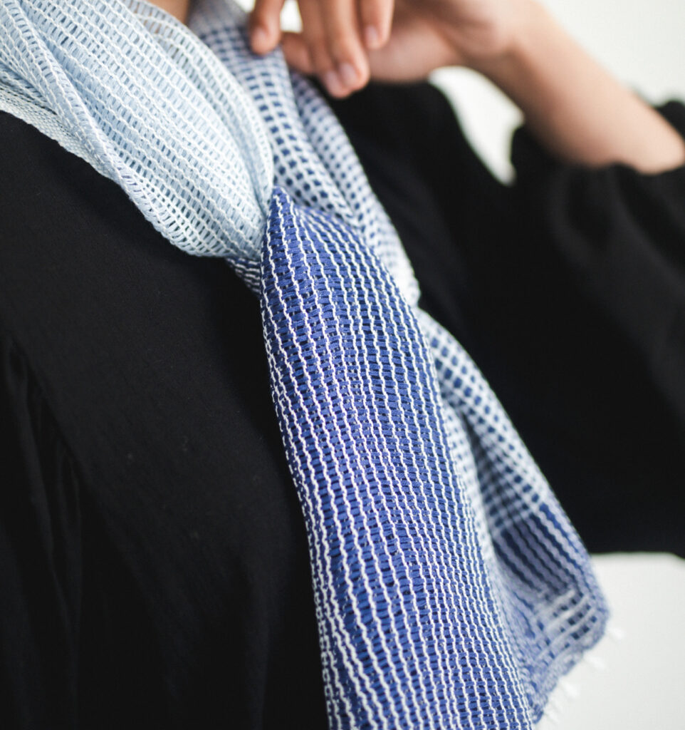 たてよろけもじり織りショートマフラー 青 着用画像